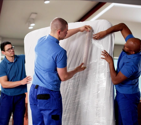 Professional movers wrapping and protecting large furniture for safe transport by City of Angels Move